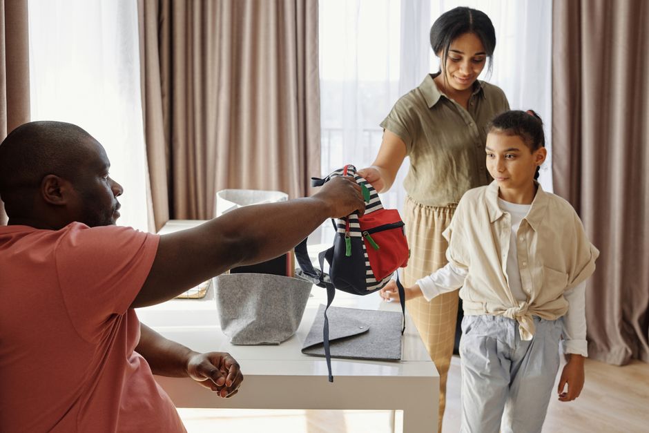 Parents helping their daughter get ready for school at home